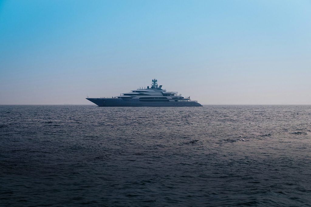 Large superyacht anchored at sea under a clear sky