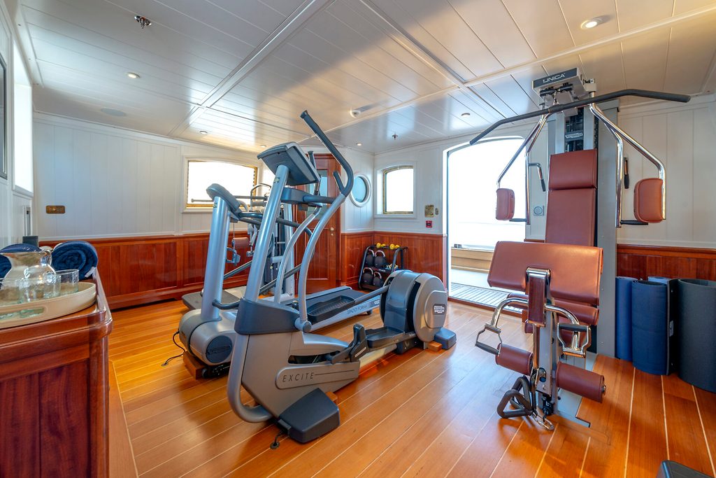 Gym with elliptical trainer and weight machine aboard a yacht