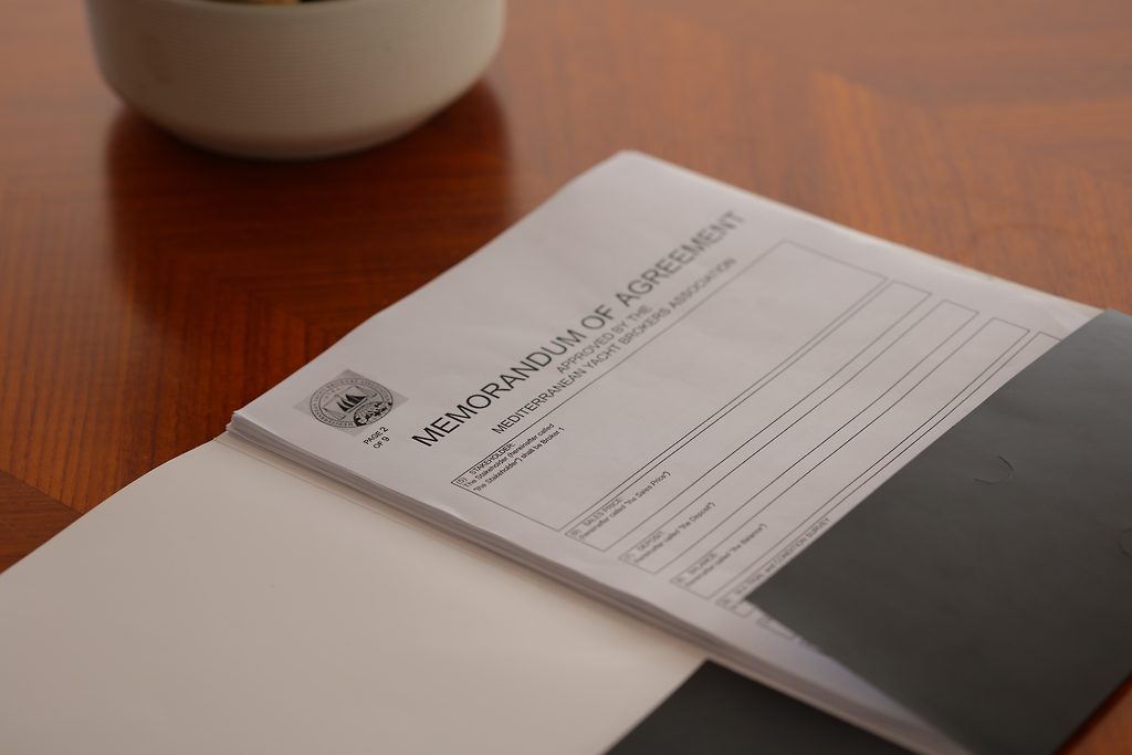 Memorandum of Agreement de la Mediterranean Yacht Brokers Association sur une table en bois