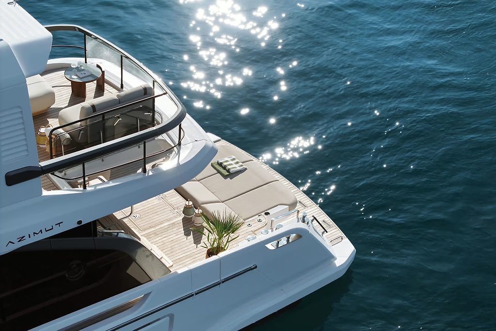 Azimut motor yacht's bow deck with sun loungers, seen from above on sparkling water