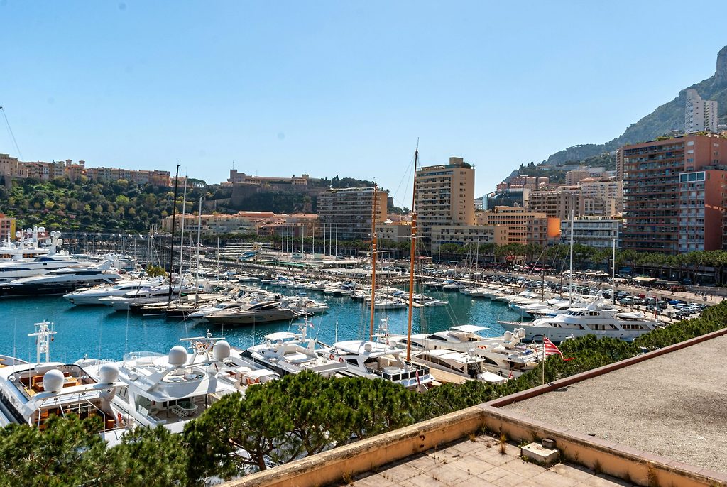 Yachten und Segelboote im Hafen von Monaco, mit der Stadt und Hügelgebäuden im Hintergrund