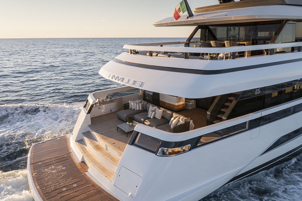 Stern view of a superyacht with multiple deck terraces, underway at sea