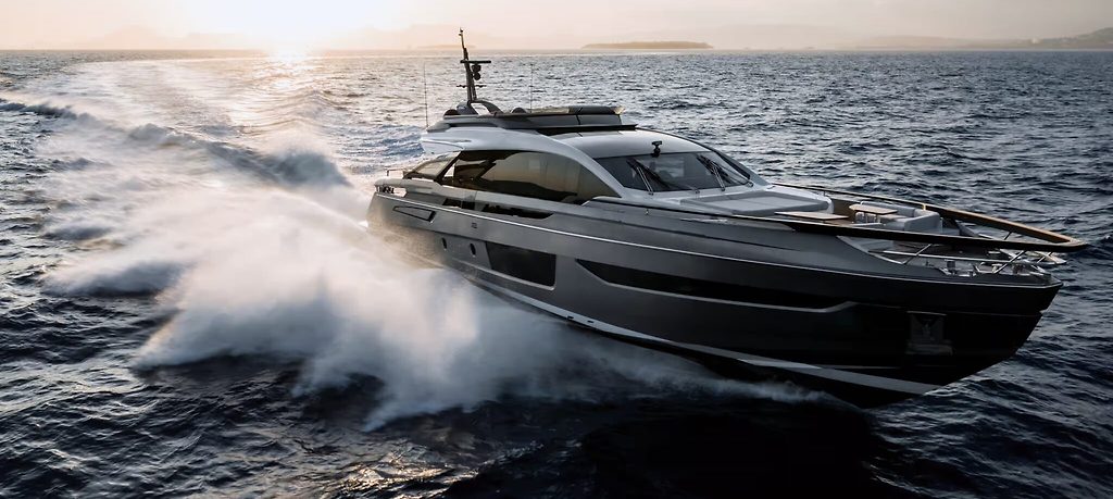 Yate a motor a toda velocidad sobre agua abierta, levantando espuma al atardecer