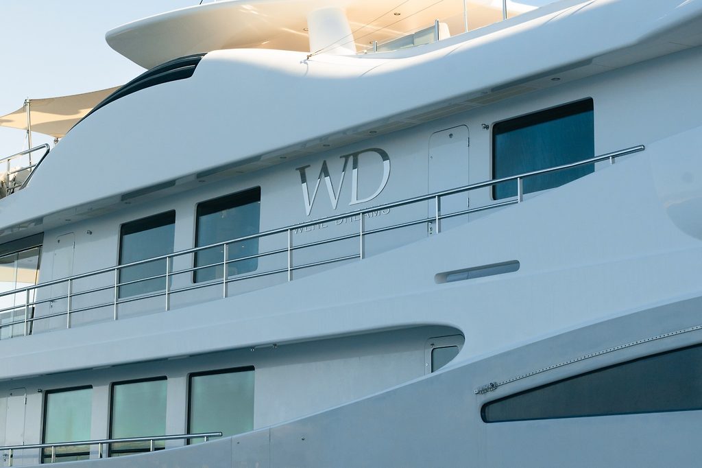Superyacht hull with deck railings and tinted windows, close-up view