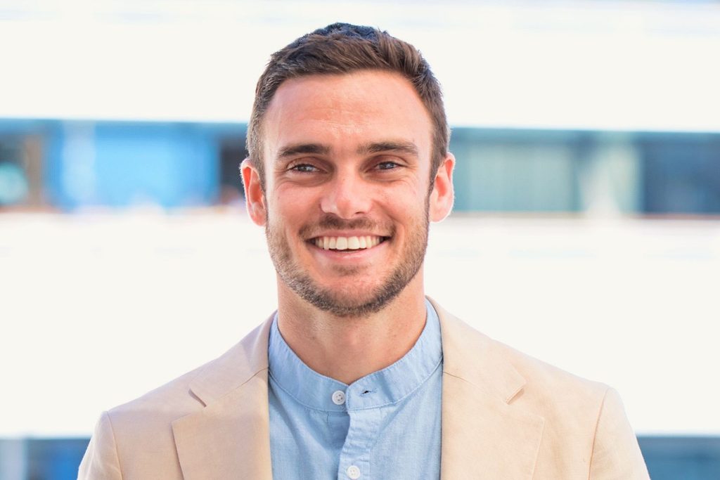 Homme en veste beige souriant à l'extérieur