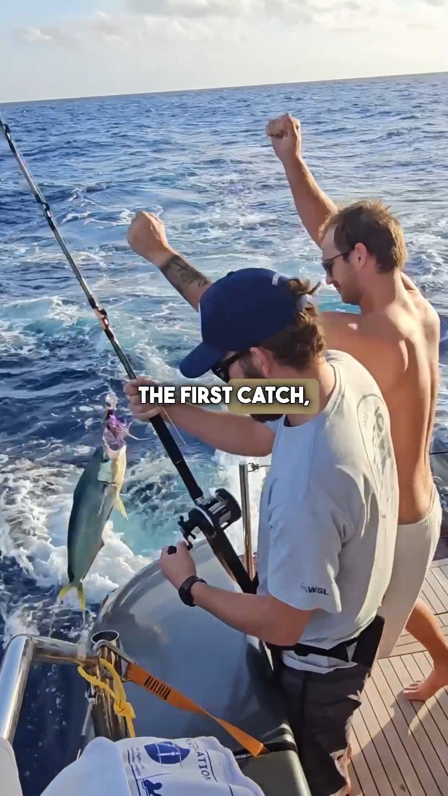 Zwei Männer freuen sich über einen Fischfang beim Hochseefischen von einer Yacht aus