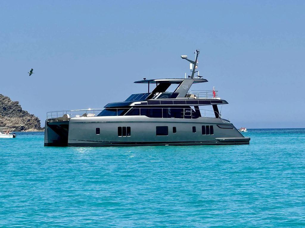 Catamaran Sunreef 60 Power ancré près d'une côte rocheuse, eau turquoise