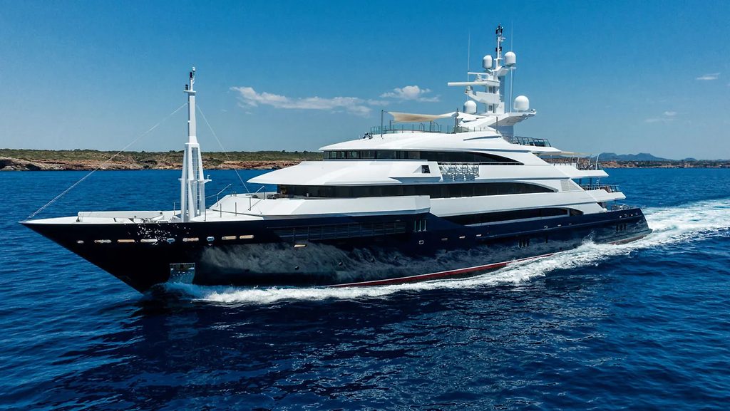 Superyacht naviguant près d'une côte sous un ciel dégagé