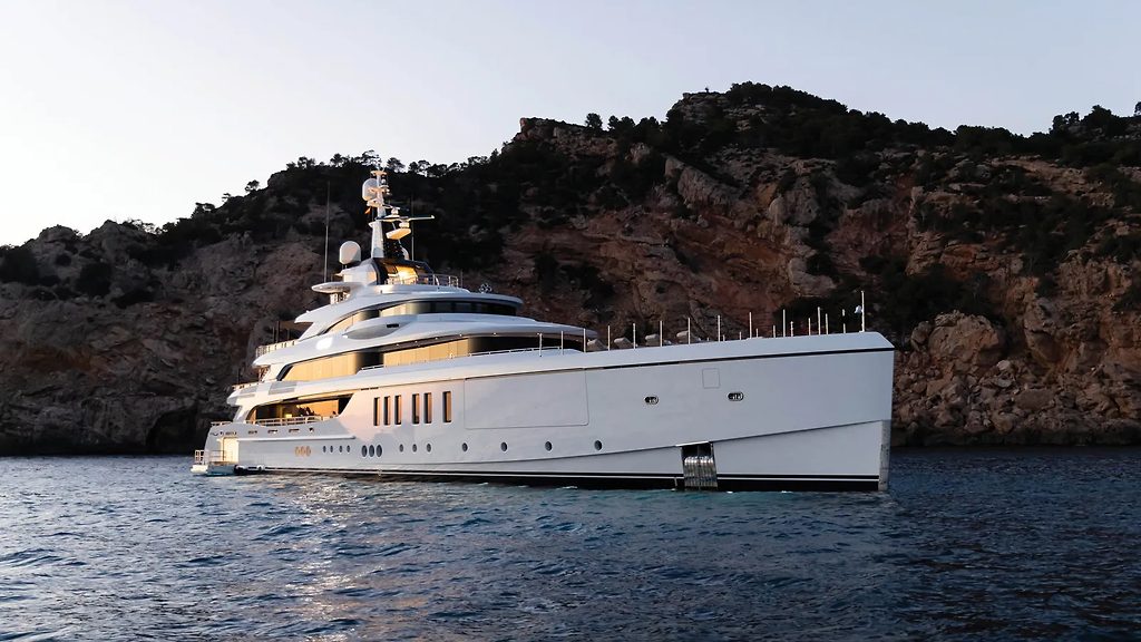 Superyacht ancré près d'une côte rocheuse au crépuscule