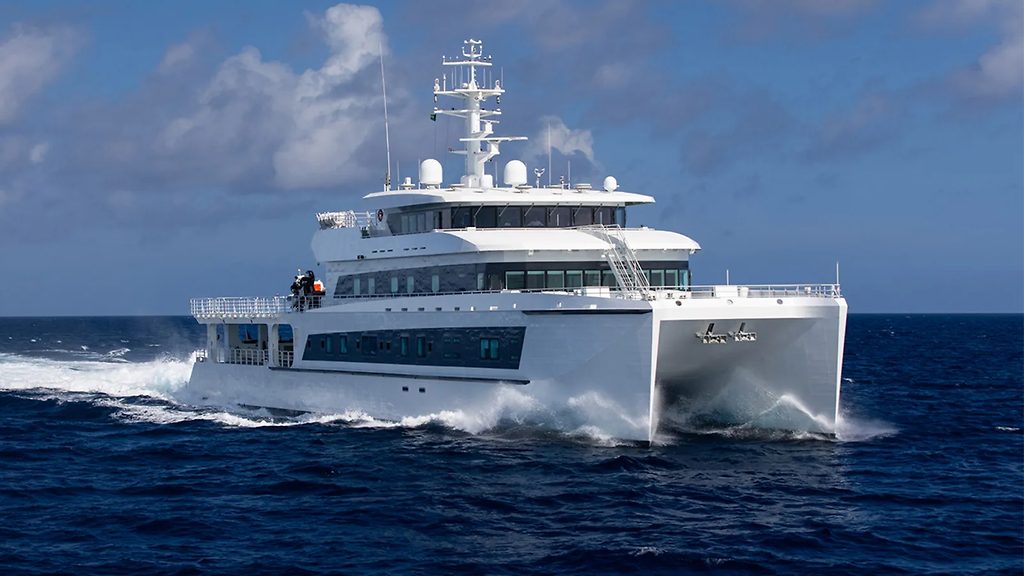 Yacht catamaran de soutien filant à vive allure en mer ouverte