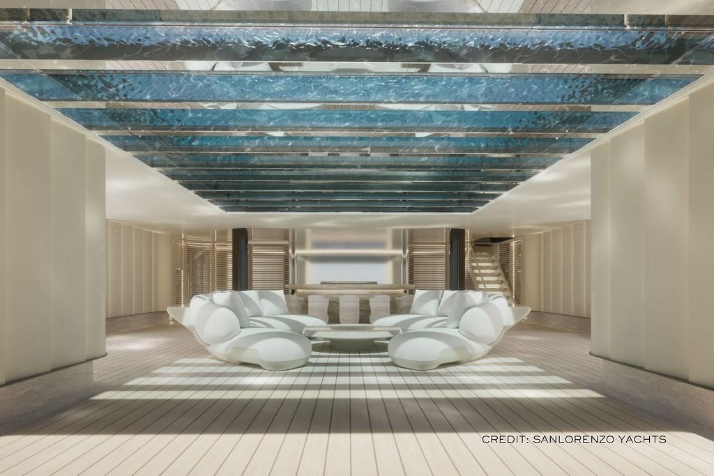 Geschwungene weisse Loungesitzgruppe unter einer Glasdecke mit Pool darüber, auf dem Unterdeck einer Superyacht