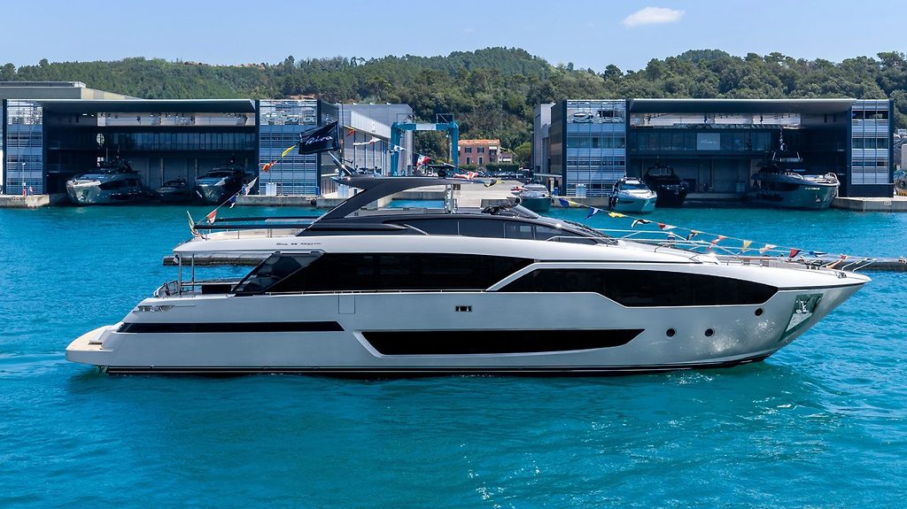 Yacht a motore Riva 96 Argo Super ormeggiato vicino agli edifici del porto, decorato con bandiere