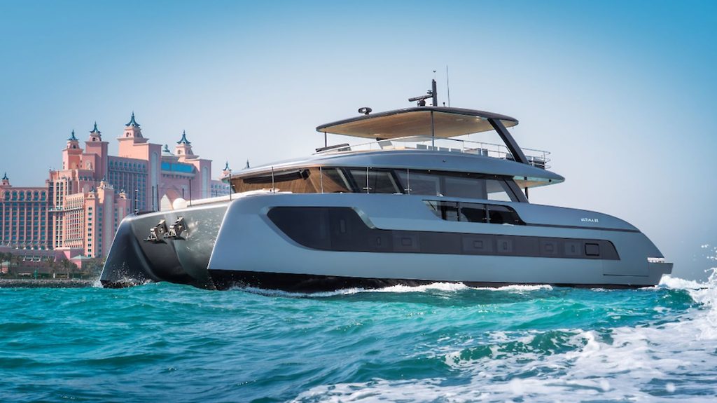 Catamarano a motore che naviga davanti a un hotel sul lungomare