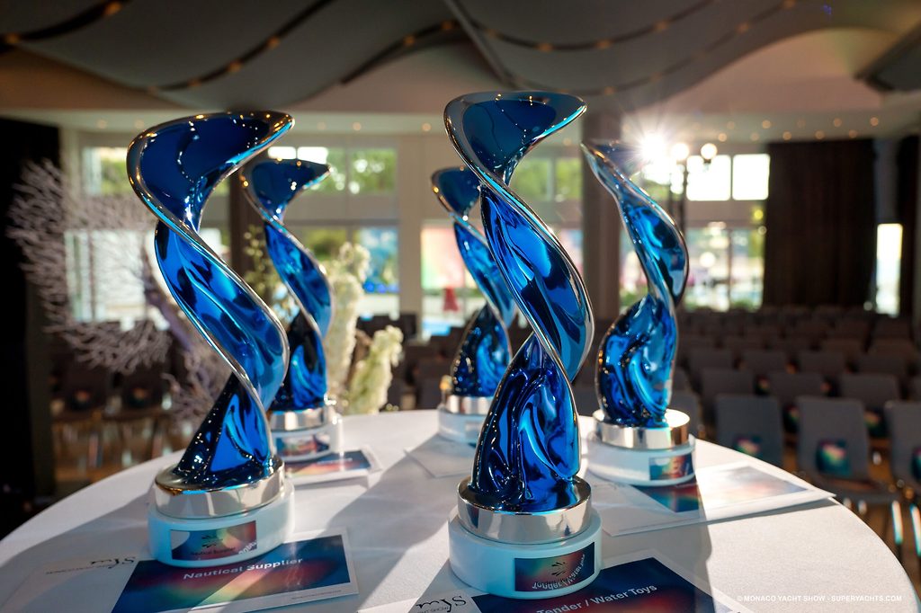 Trofei a spirale in vetro blu su un tavolo in una sala per cerimonie di premiazione